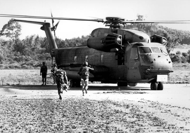 May 16, 1975-
A Marine and Air Force pararescueman of the 40th Aerospace Rescue and Recovery Squadron (in wet suit) run for an Air Force helicopter during an asualt on Koh Tang Island to rescue the U.S. Merchant ship Mayaguez and its crew May 15, 1975.