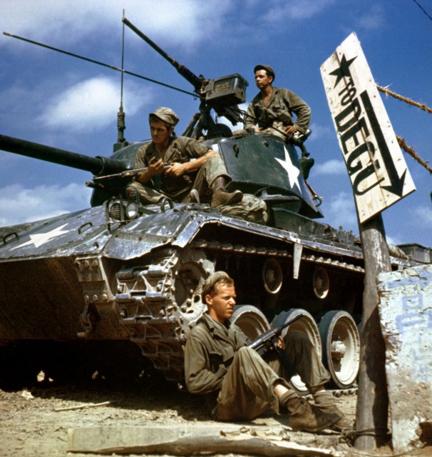 Crew of an M-24 tank along the Naktong River front.  On the ground is Pfc. Rudolph Dotts, Egg Harbor City, N.J. gunner (center); Pvt. Maynard Linaweaver, Lundsburg, Kansas, cannoner; and on top is Pfc. Hugh Goodwin, Decature, Miss., tank commander. All are members of the 24th Reconnaissance, 24th Division. NARA FILE#:  111-C-6061