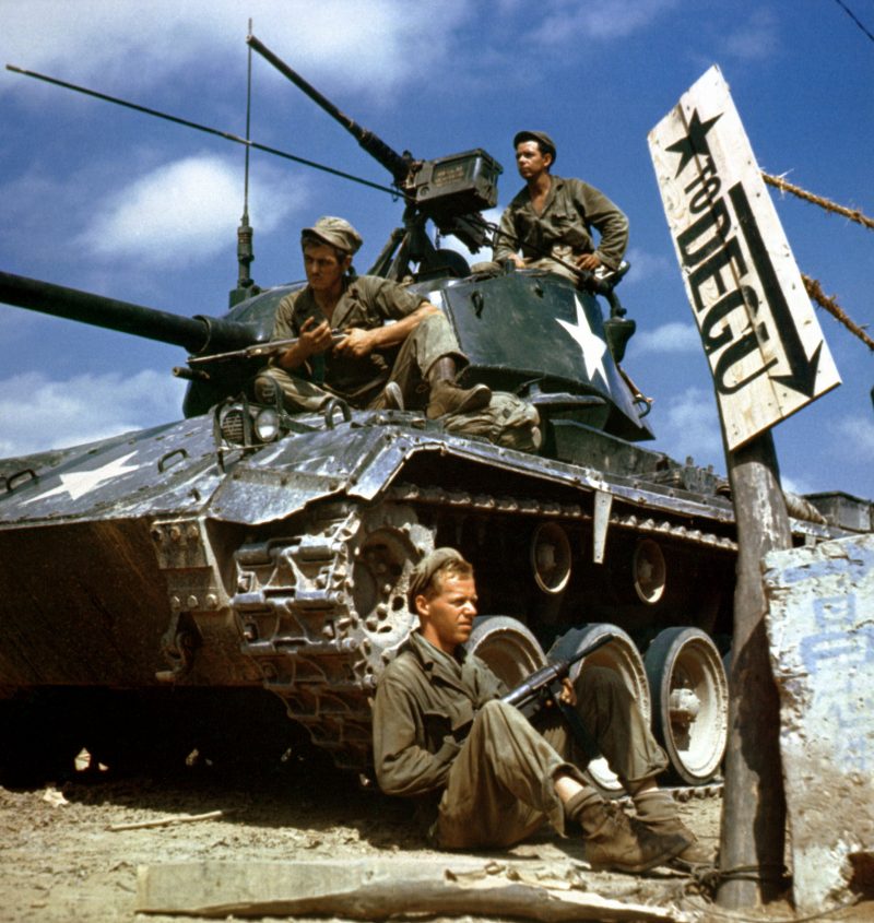 Crew of an M-24 tank along the Naktong River front.  On the ground is Pfc. Rudolph Dotts, Egg Harbor City, N.J. gunner (center); Pvt. Maynard Linaweaver, Lundsburg, Kansas, cannoner; and on top is Pfc. Hugh Goodwin, Decature, Miss., tank commander. All are members of the 24th Reconnaissance, 24th Division.
NARA FILE#:  111-C-6061