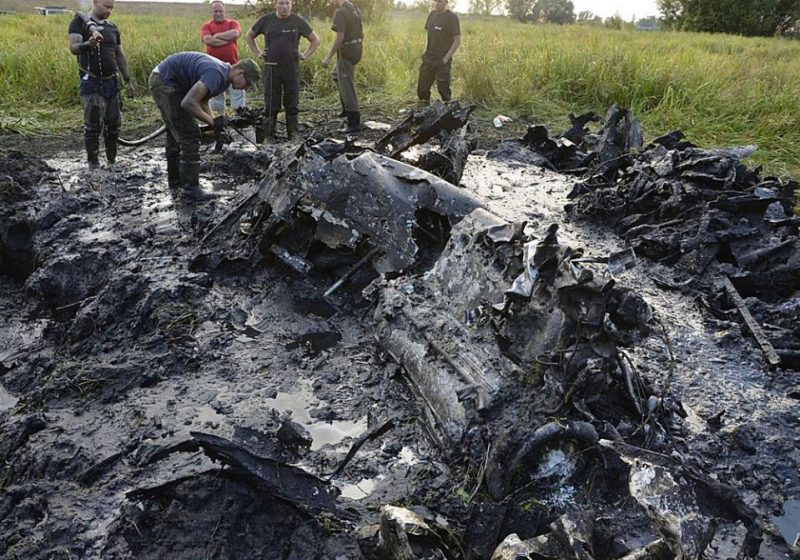 In this Aug. 23, 2015  photo made available by the firefighter brigade  in Wyszogrod, central Poland,  firefighters are retrieving the remains of a Soviet WW II fighter-bomber plane from muddy riverbed near Wyszogrod,. The Red Army plane was downed by the Germans in January 1945 and plunged into the  frosty river. Recent drought that brought river levels down has made access to the remains possible. (AP Photo/OSP Wyszogrod)    MANDATORY CREDIT
