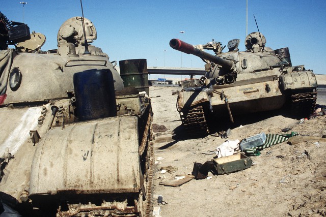Two Iraqi T-55 main battle tanks lie abandoned on the Basra-Kuwait Highway near Kuwait City after the release of Iraqi forces from the city during Operation Desert Storm.