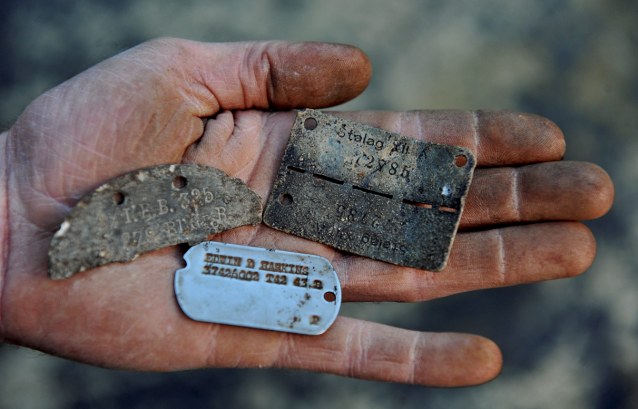 A selection of dog tags (English, American and German) found by David Murray, 39, of Much Hadham, Hertfordshire, after he discovered a World War II prisoner of war camp at the bottom of his back garden. The camp, now known to be Wynches Camp 411, was built in 1939 and was operational until at least 1948. See MASONS story MNCAMP; A shocked plumber has discovered a prisoner of war camp that housed 10,000 German soldiers during the Second World War - in his BACK GARDEN. David Murray, 39, was digging in the garden behind his bungalow in Much Hadham, Herts., when he unearthed a dog tag from a German prisoner. He got permission from his landlord to continue excavations and within an hour he had located old bottles, buttons from uniforms and used ammunition. David has now recovered more than 2,000 items from the camp, including a live GRENADE that had to be blown up by a RAF bomb disposal unit.