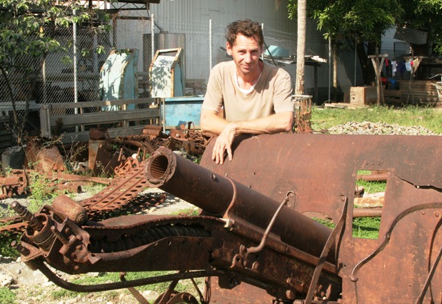 Kurt Markworth with a recovered Japanese howitzer in his yard at Honiara. Kurt and brother Anders have recovered tons of relics and scores of bodies. (RE)