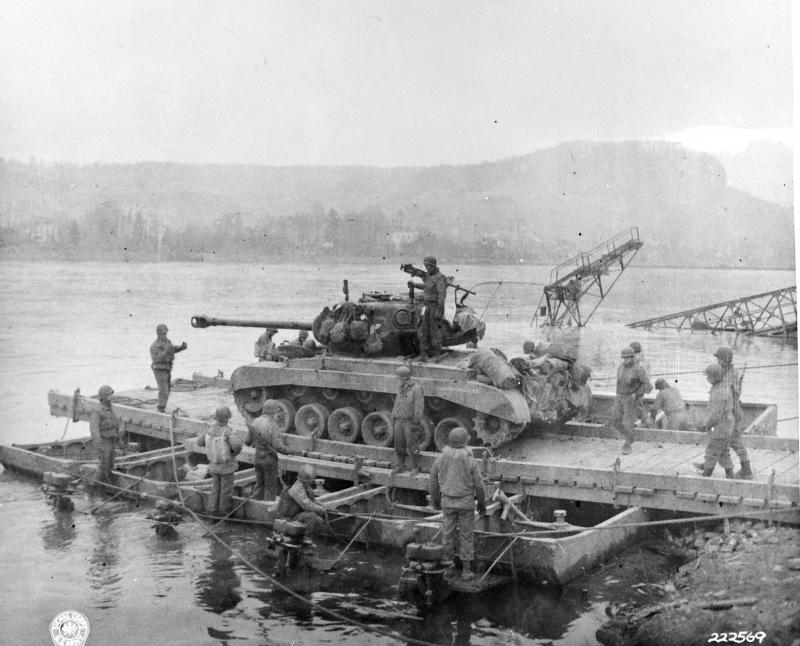 An M26 Pershing T26E3 of A Company, 14th Tank Battalion, is transported aboard a pontoon ferry built by the First Engineer Heavy Pontoon Battalion across the Rhine on 12 March 1945.