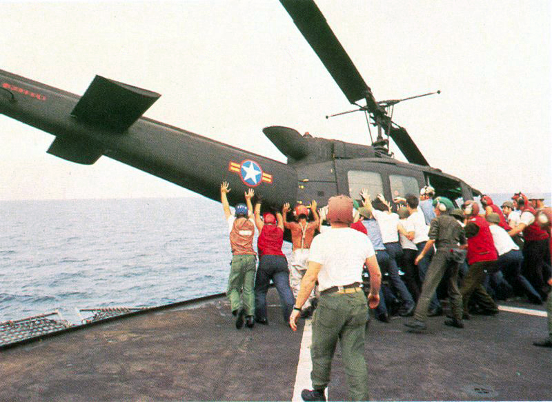 CAMP FOSTER, OKINAWA, Japan ・South Vietnamese UH-1H being pushed overboard to make room for a Cessna O-1 landing. Operation Frequent Wind, the final operation in Saigon, began April 29, 1975. During a nearly constant barrage of explosions, the Marines loaded American and Vietnamese civilians, who feared for their lives, onto helicopters that brought them to waiting aircraft carriers. The Navy vessels brought them to the Philippines and eventually to Camp Pendleton, Calif. (Official U.S. Navy photo) (released)