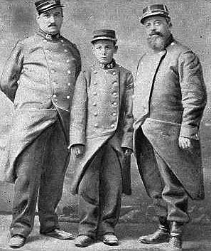 Edouard, an orphan, is probably 15-years-old in this picture. He is shown standing with his "new parents," members of the French military. To glorify his service, the caption calls him Le Petite Bleu (the little blue) because of the blue pants all poilu (common soldiers) wear