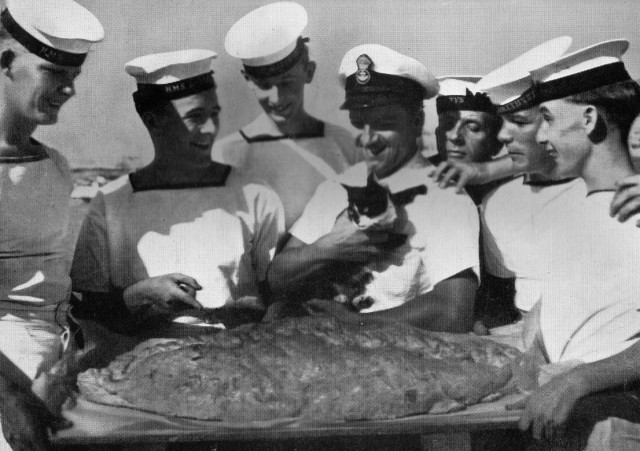 Simon and his fellow crew members admiring a giant pie