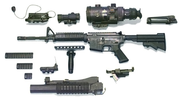 M4 MWS (Modular Weapon System) shown with various accessories including M203 grenade launcher, RIS foregrip, removable carry handle/rear sight assembly, AN/PEQ-4 laser system, M68 CCO reflex sight, and the AN/PVS-4 night vision optics