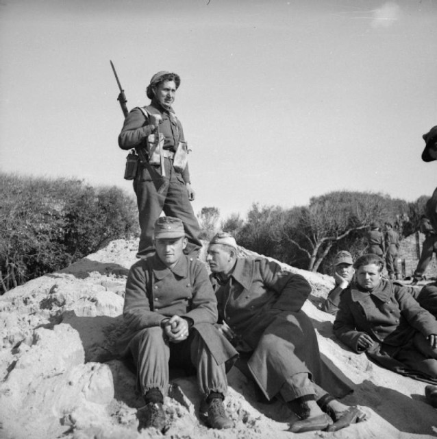 A British soldier guards German prisoners at Anzio, 22 January 1944. By Menzies (Sgt), No 2 Army Film & Photographic Unit