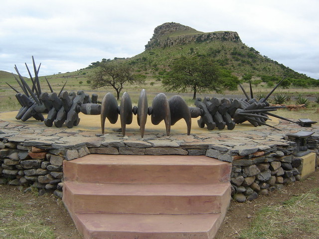 Zulu memorial to the fallen. the statue is a representation of a necklace awarded or made for displays of bravery. the Isandlwana hill rises in the background.