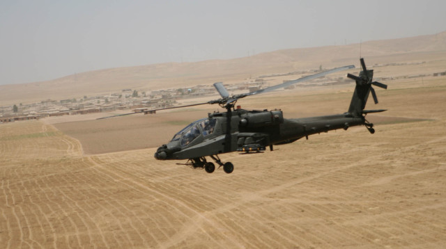 An AH-64D Apache Longbow attack helicopter flies over the desert terrain between Tall’Afar and Mosul, Iraq, June 14.
