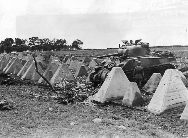 M4_Sherman_of_the_3rd_Armored_Division_Crossing_Dragons_Teeth_of_Siegfried_Line_September_1944_Roeten