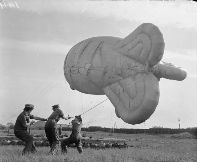 British female military auxiliaries handle a barrage balloon.
