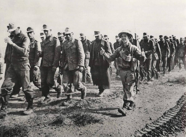 A British soldier escorting German POWs into Tobruk in 1941 