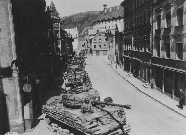 long_row_of_M4A3_76_W_Sherman_HVSS_tanks_enter_Echstatt_Germany_1945