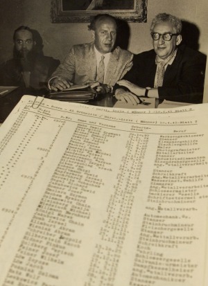 A photograph of Oskar Schindler (centre) and what is thought to be the original list.