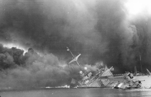 smoke pours from a sinking cruiser (photo Bundesarchiv, Bild & Vennemann, Wolfgang from Wikipedia.org)
