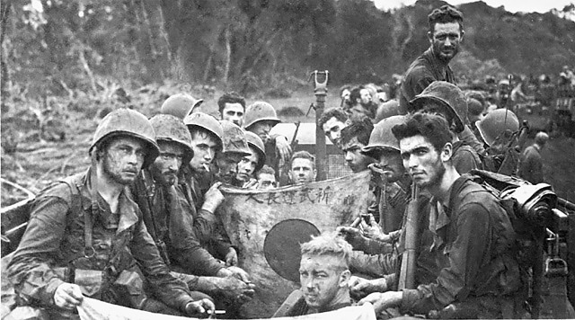 Soldiers of the 1st Marine Division display Japanese flags captured during the Battle of Cape Gloucester