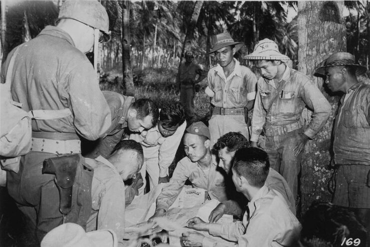 American soldiers and Filipino guerrillas looking at a map