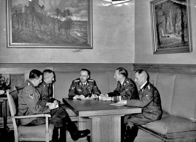 1939 photograph; shown from left to right are Franz Josef Huber, Arthur Nebe, Heinrich Himmler, Reinhard Heydrich and Heinrich Müller, planning the investigation of the bomb assassination attempt on Adolf Hitler of 8 November 1939 in Munich. - Bundesarchiv CC-BY-SA 3.0