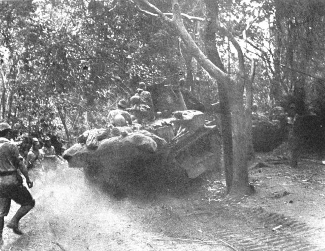Japanese tanks and infantry advance through the Bataan jungle.