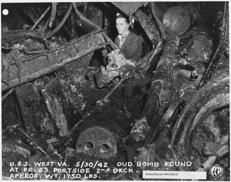 Shipyard worker inspecting interior damage in 1942
