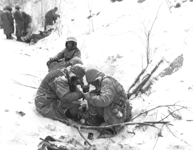 Marines huddling for warmth at Chosin Reservoir in Korea via commons.wikimedia.org