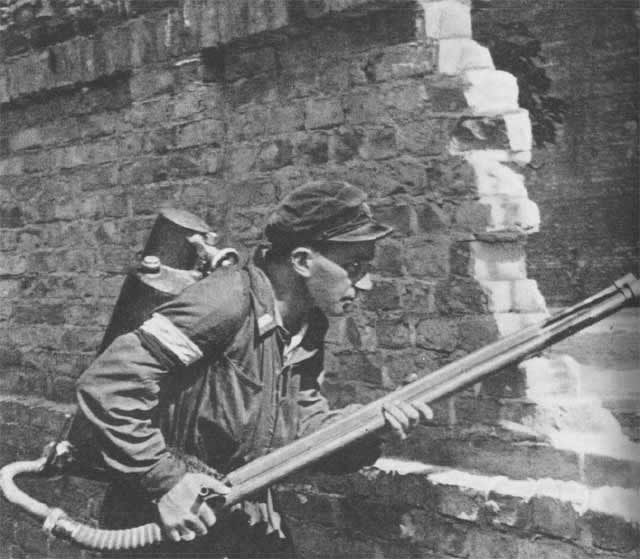 A Home Army fighter wielding a K-pattern flamethrower on the streets of Warsaw, 1944