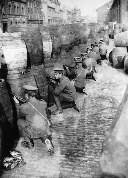 British soldiers in position behind a stack of barrels during the Rising in Dublin.