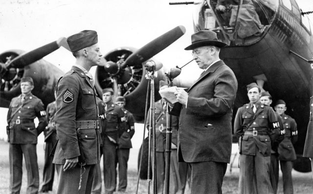 Staff Sergeant Maynard Smith of the 306th Bombardment Group, is presented with the Medal of Honor by Secretary of War Henry L Stimson in front of a B-17 Flying Fortress at Thurleigh Airfield, USAAF Station 111, England.