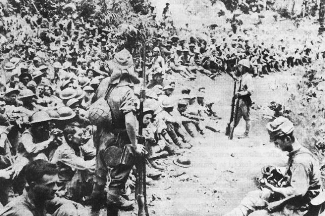 Japanese soldiers guard American and Filipino prisoners of war.