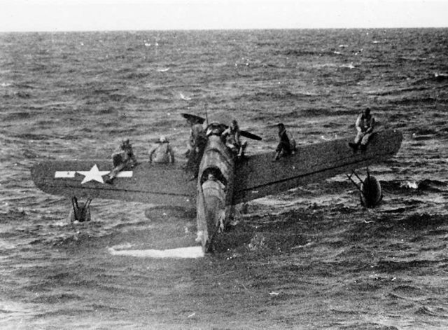 Downed American airmen near Truk Lagoon are ferried by a Vought OS2U Kingfisher to USS Tang.