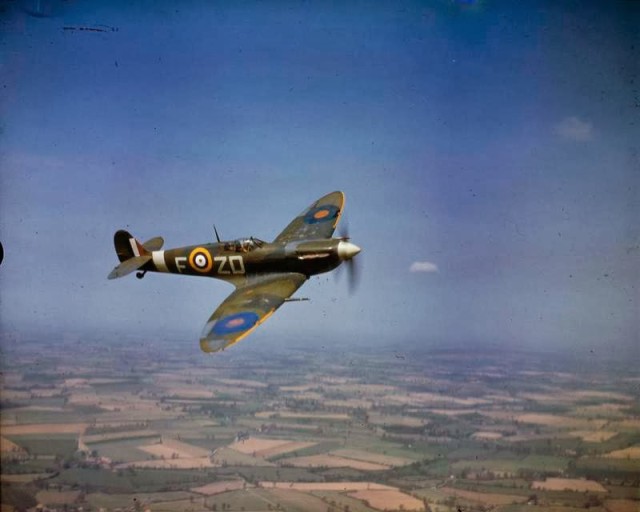 A Spitfire in flight over England, 1939-1945. © IWM (COL 189)