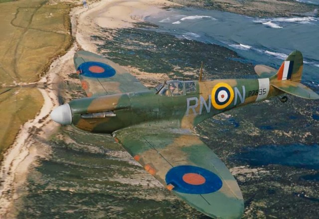 A Spitfire in flight over the English coast. © IWM (TR 139)