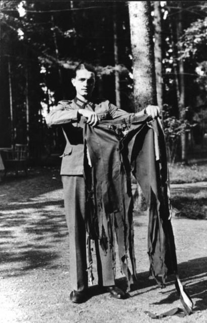 A soldier holding the trousers Hitler wore during the failed assassination attempt. Photo Credit.