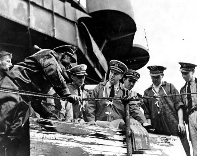 Captain Homer N. Wallin (center) supervises salvage operations aboard USS California, early 1942.