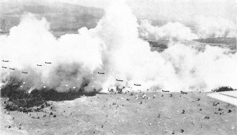 Dwarfed by and silhouetted against clouds of smoke (created to provide concealment), C-47s from the USAAF drop a battalion of the 503rd at Nadzab, New Guinea. A battalion dropped moments earlier is landing in the foreground