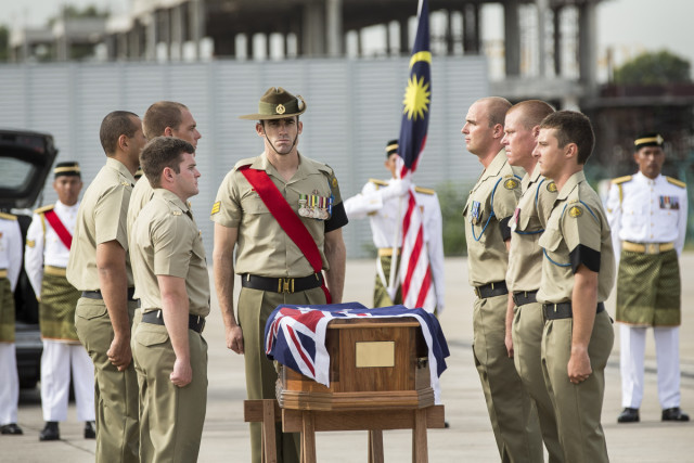Australian Army soldiers from 3rd Brigade, based at Lavarack Barracks in Townsville, prepare to carry one of the coffins of the 33 Australian service personnel and dependants into a Royal Australian Air Force C-17A Globemaster aircraft during the ceremony at Subang airport, Malaysia, on Tuesday, 31 May 2016.
