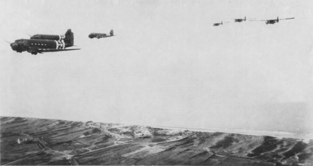 C-47s of the 9th Air Force Troop Carrier Command tow reinforcements in CG-4 gliders across the Normandy beaches on June 6, 1944 (Image).