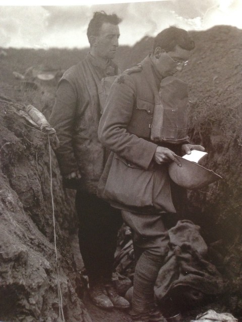 Chaplain of the Royal Munster Fusiliers praying over the bodies of the dead buried on the battlefield. 1916.