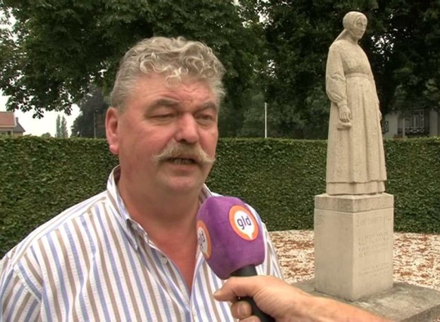 Jannes Priem standing before the Lady of Putten memorial