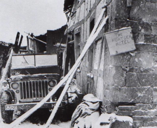 A farmhouse on the main route through Hürtgen served as shelter for HQ Company, 121st Infantry Regiment, 8th Infantry Division, XIX Corps, 9th US Army, as indicated on the bumper of the jeep. They nicknamed it the "Hürtgen Hotel".