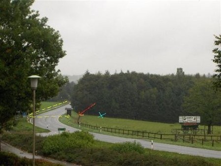 This photo was taken beside the memorial facing south toward the road where the incident happened. Lengfelled walked along the area marked by the yellow line to get to the American soldier (blue X). As he got off the road, he stepped on the mine indicated by the red Xarrow