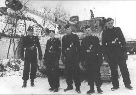 Wittmannn’s Tiger S04 and his crew. The second one from the left is Bobi Woll. By Bundesarchiv, CC-BY-SA 3.0, CC BY-SA 3.0 de