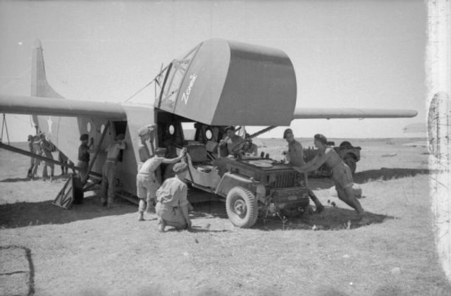 A jeep is loaded onto an American WACO CG-4A glider before Operation Husky. July, 1943. [© IWM (CNA 1662)]