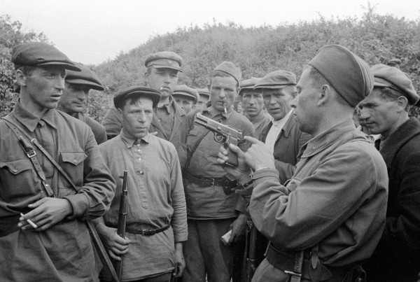 A Soviet soldier teaching partisan fighters how to operate a Browning Hi-Power handgun, near Smolensk. 23 August 1941 [Via].