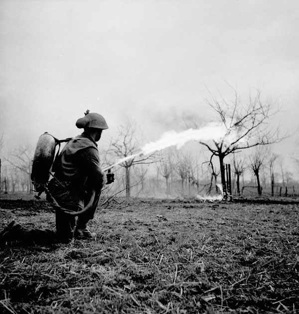 Lance-Corporal J.E. Cunningham of The Essex Scottish Regiment practices firing a Lifebuoy flamethrower near Xanten, Germany, 10 March 1945 [MIKAN: 3524539]