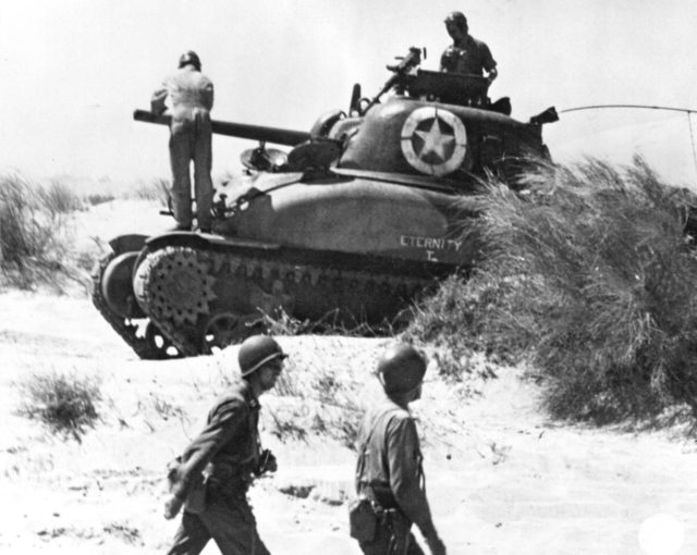 Crew from the tank "Eternity" check their vehicle after landing at Red Beach 2, Sicily. 10 July 1943. [Signal Corps Photo: MM-43-01-32 (Osborne)]