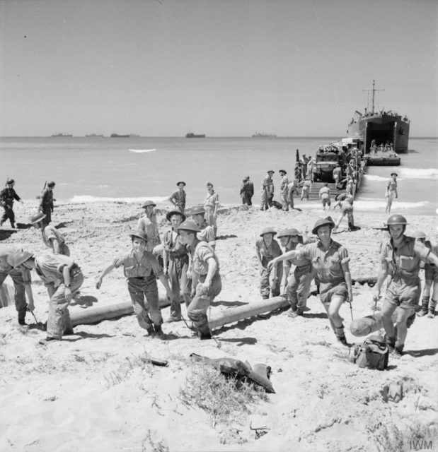 Personnel of a Beach Balloon Detachment bring gas cylinders ashore at "Cent" Beach near Scoglitti, Sicily. [© IWM (CNA 4180)]