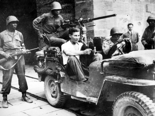 Soldiers of the 92nd Infantry Division with a captured German soldier. - Wikipedia / Public Domain